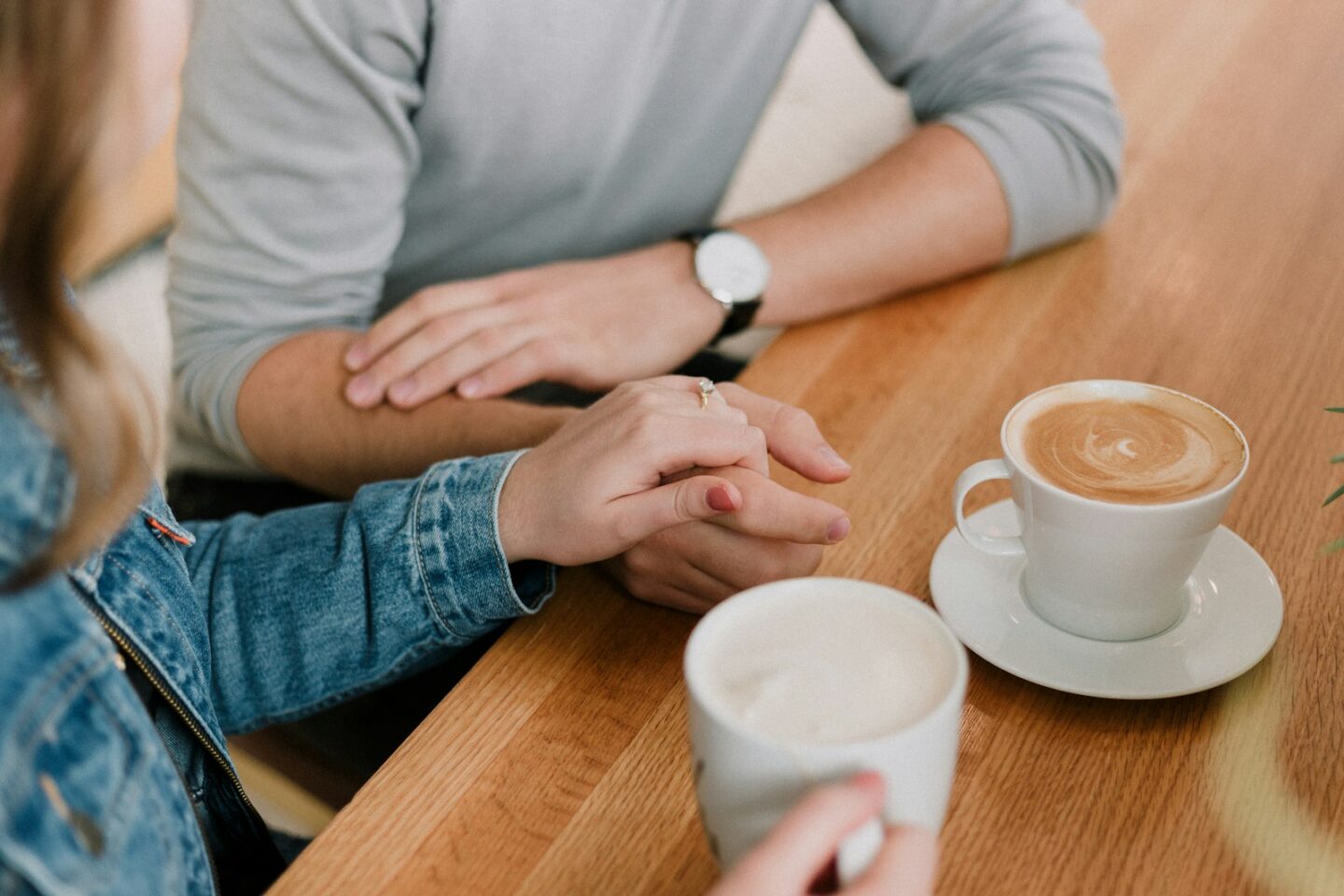 Partners holding hands over coffee, EFT couples therapy at Common Thread Counseling