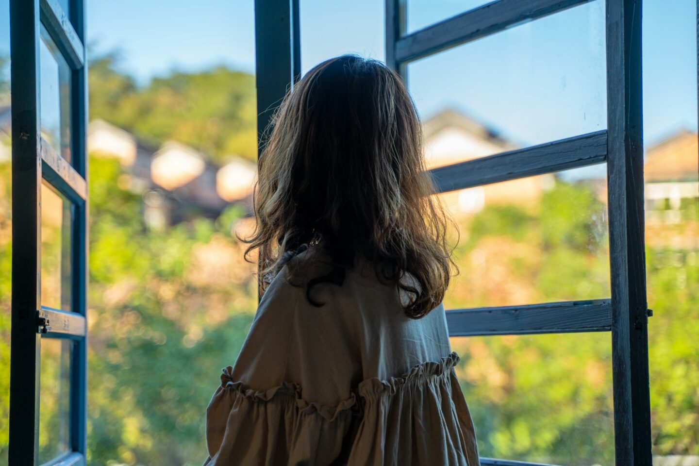 Woman reflecting by an open window, individual EFT therapy in Anchorage