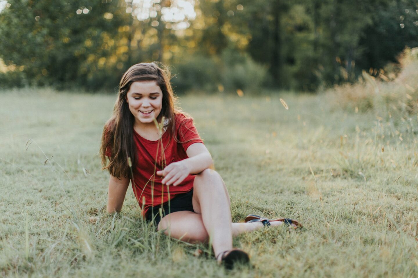 Relaxed teen sitting in a grassy field, therapy for teens in South Anchorage